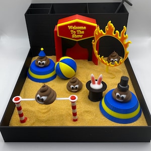 Puede incluir: Una escena de circo caprichosa con un letrero que dice "Welcome To The Show". La escena incluye un aro de fuego, un sombrero de mago con orejas de conejo y varios emojis de caca con sombreros y expresiones.