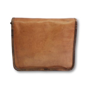 May include: A brown leather messenger bag with a flap closure and a brown strap. The bag has a worn, vintage look.