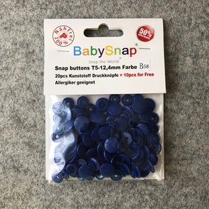 Peut inclure: Un paquet de 20 boutons-pression en plastique bleu, taille T5-12,4 mm, avec 10 boutons gratuits. L'emballage indique "BabySnap Snap the World" et "Allergiker geeignet".