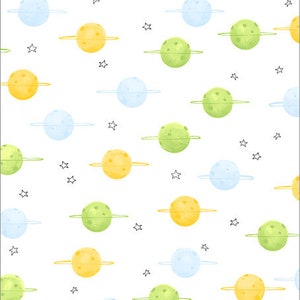 Könnte beinhalten: Weißer Stoff mit einem sich wiederholenden Muster aus gelben, grünen und blauen Planeten, jeweils mit einem dünnen Ring. Kleine schwarze Sterne sind zwischen den Planeten verstreut. Das Design ist skurril und für Kinderartikel geeignet.