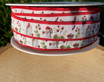 Könnte beinhalten: Eine Rolle dekorativen Bandes mit einem sich wiederholenden Muster aus Zwergen, Erdbeeren und Vögeln auf weißem Hintergrund. Das Band hat rote Ränder und wird auf einem weißen Teller präsentiert, ideal zum Basteln und Geschenkverpacken.