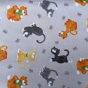 Może przedstawiać: Jasnoszara tkanina z powtarzającym się wzorem zabawnych kotów z kreskówek w kolorze pomarańczowym, żółtym, szarym i czarnym. Koty są w różnych pozach, z odciskami łap rozrzuconymi po całym wzorze. Idealna do szycia.