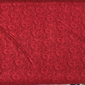 Peut inclure: Tissu rouge avec un motif de tourbillon noir.