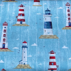 Può includere: Tessuto con un motivo ripetuto di fari in vari disegni. I fari sono bianchi, rossi e blu, su uno sfondo azzurro con un sottile motivo a onde. Piccole nuvole e uccelli sono anche sparsi sul tessuto.