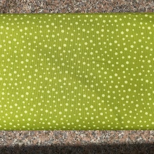 Puede incluir: Tela verde con un patrón de lunares blancos.