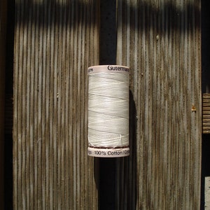 May include: A white spool of Gutermann 100% cotton thread.
