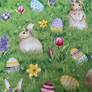 Peut inclure: Un tissu vert avec un motif répété de lapins de Pâques, de fleurs et d'œufs. Les lapins portent des couronnes de fleurs et les œufs sont décorés de rayures et de pois.