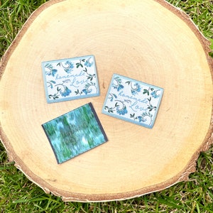 Könnte beinhalten: Zwei blaue und weiße Stoff-Etiketten mit dem Text "homemade with love" und einem floralen Design. Ein drittes Etikett mit einem blauen und grünen abstrakten Muster.
