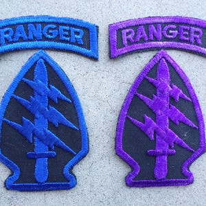May include: Two black embroidered patches with a lightning bolt design and the word "RANGER" in blue and purple lettering on a blue and purple banner above each patch.
