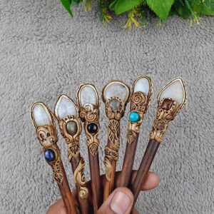 May include: Seven wooden hair sticks with decorative carvings and gemstone accents. The sticks are brown and the carvings are white. The gemstones are various colors, including blue, green, and turquoise.