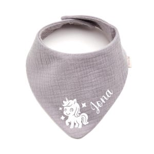 Könnte beinhalten: Graues Baby-Lätzchen mit einem weißen Einhorn-Motiv und dem Namen "Jona" in Schreibschrift. Das Lätzchen ist aus weichem Stoff und hat eine dreieckige Form mit Druckknopfverschluss.