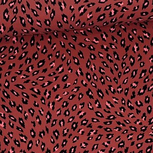 May include: Red fabric with a black and pink leopard print pattern.