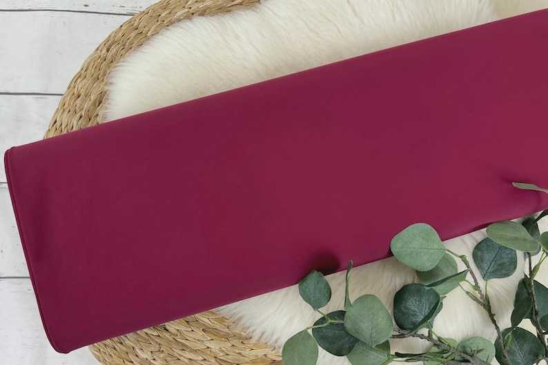 May include: A solid, deep burgundy fabric swatch. The fabric is smooth and has a slight sheen.