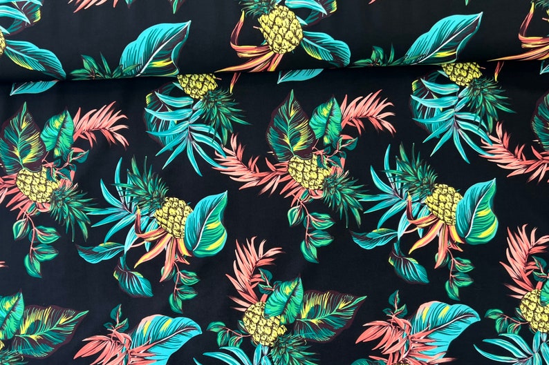 May include: Black fabric with a tropical print featuring pineapples and palm leaves in shades of green, yellow, and pink.