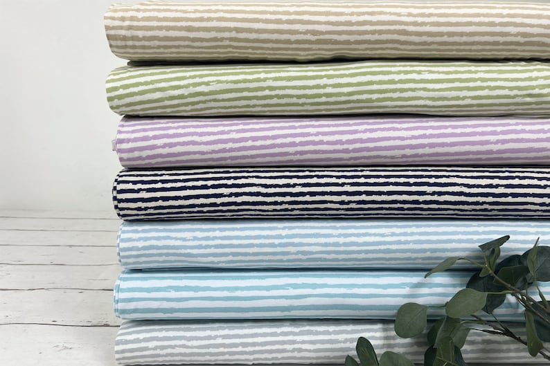 Pu&ograve; includere: Un set di sei campioni di tessuto con diversi motivi a righe. I campioni sono di vari colori, tra cui beige, verde, viola, blu navy, blu chiaro e grigio.