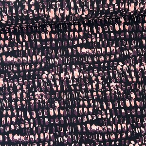 May include: Black fabric with a repeating pattern of pink and purple abstract shapes.