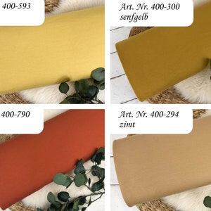 Puede incluir: Cuatro muestras de tela en diferentes colores: amarillo mostaza, amarillo oscuro, naranja &oacute;xido y beige. Las muestras est&aacute;n etiquetadas con sus n&uacute;meros de art&iacute;culo y nombres de color en alem&aacute;n: "Art. Nr. 400-593 kamille", "Art. Nr. 400-300 senfgelb", "Art. Nr. 400-790 rost" y "Art. Nr. 400-294 zimt".