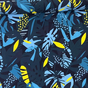 May include: A dark blue fabric with a repeating pattern of blue and yellow stylized leaves. The fabric has a tropical theme.