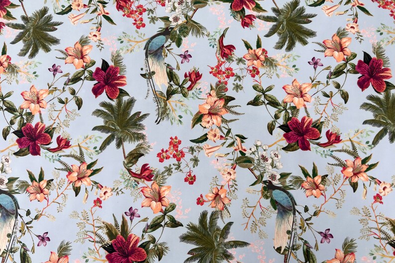 May include: A light blue fabric with a tropical print featuring pink, red, and green flowers, palm trees, and peacocks.
