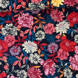 May include: A navy blue fabric with a floral print featuring red, pink, yellow, and white flowers. The fabric has a busy pattern with many flowers and leaves.