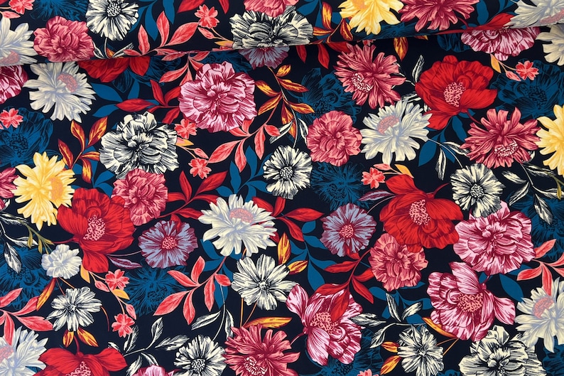 May include: A navy blue fabric with a floral print featuring red, pink, yellow, and white flowers. The fabric has a busy pattern with many flowers and leaves.