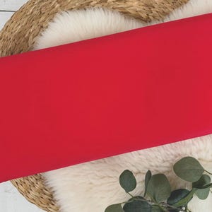 May include: A bright red fabric swatch, perfect for crafting projects or sewing garments.