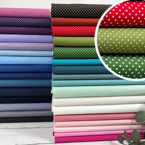 Peut inclure: Une pile de tissu de différentes couleurs avec des pois blancs. Le tissu est plié soigneusement et disposé en pile verticale. Le tissu est un choix populaire pour les projets de couture et d'artisanat.