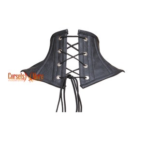 May include: Black leather corset with a lace-up front and a pointed shape. The corset has a textured surface and is designed to be worn as a fashion accessory.