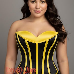 May include: A strapless corset featuring a sweetheart neckline with alternating vertical panels of black and bright yellow satin fabric. The garment has a structured bodice design with a smooth finish and a logo in the bottom left corner reading Corsets More.