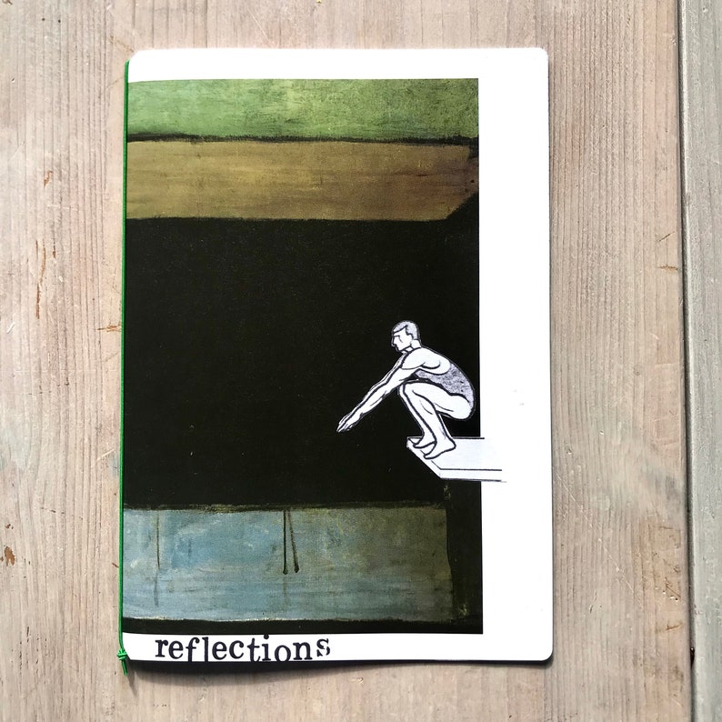 Puede incluir: Un cuaderno con lomo verde y la palabra "reflections" en la parte inferior. La portada presenta una ilustraci&oacute;n de una persona a punto de zambullirse en un cuerpo de agua oscura, con formas abstractas verdes y azules.