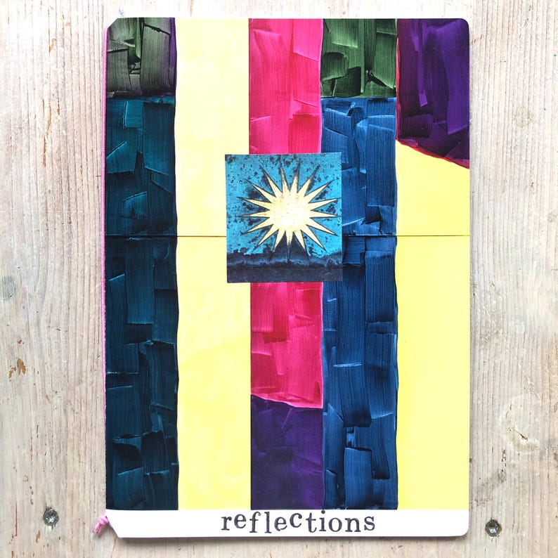 Puede incluir: Un diario colorido con un dise&ntilde;o abstracto pintado. Rayas verticales de color turquesa, rosa, amarillo, azul, verde y morado crean un fondo vibrante. Una imagen cuadrada de un sol sobre un paisaje monta&ntilde;oso est&aacute; centrada. La palabra "reflections" est&aacute; impresa en la parte inferior.