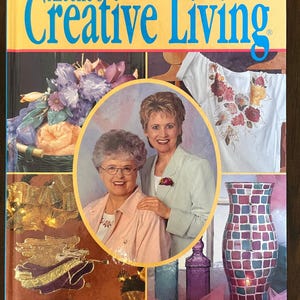 May include: A hardcover book titled Best of Aleene's Creative Living featuring a collage of craft projects including a floral basket, a painted white shirt, a mosaic vase, and a central oval portrait of two smiling individuals.