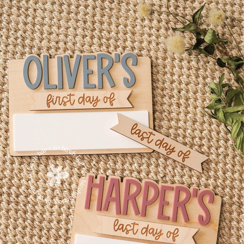 May include: Wooden signs with the names "Oliver's" and "Harper's" in gray and pink, respectively. Each sign has the phrases "first day of" and "last day of" in a banner design. A white space is available for writing.