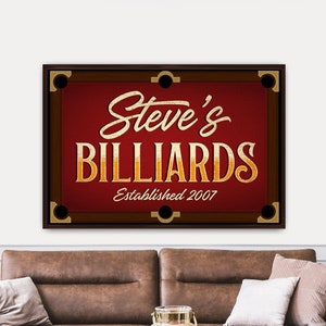 May include: A red and brown billiard table sign with gold lettering that reads "Steve's Billiards Established 2007".