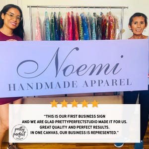 Shop owner holding personalized indoor business sign used for company branding.