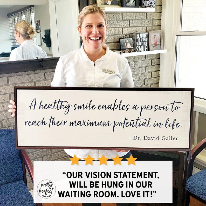 Small business owner holding personalized sign, custom indoor business signs used for office wall art and company signage.