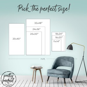 May include: A guide to choosing the perfect size for a canvas print. The image shows six different sizes of canvas prints, ranging from 11x14 inches to 32x48 inches. The prints are displayed on a light blue wall with a white wood floor. A chair and a side table are also shown in the image.