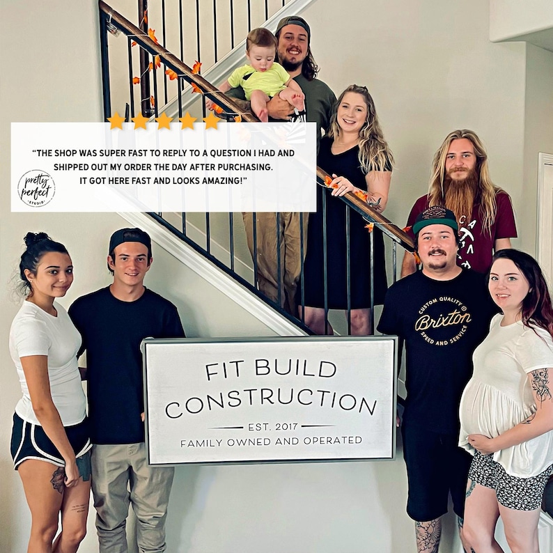 Team photo with personalized company sign used as custom indoor business signage and office wall art.
