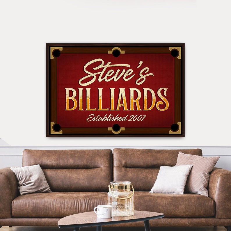 May include: A red and brown billiard table sign with gold lettering that reads "Steve's Billiards Established 2007".