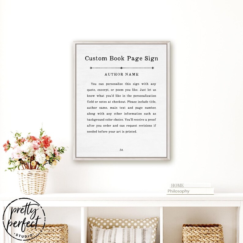 Puede incluir: Un letrero de pared rectangular enmarcado con fondo blanco y texto negro que dice Custom Book Page Sign, AUTHOR NAME, e incluye instrucciones de personalizaci&oacute;n. El letrero presenta una l&iacute;nea divisoria decorativa y el n&uacute;mero 34 abajo.