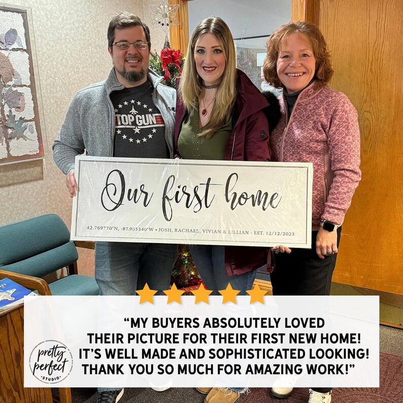 May include: A white rectangular sign with the text "Our first home" in elegant script, coordinates, names, and the date 12/12/2023. The sign is held by three people. The sign is from Pretty Perfect Studio.