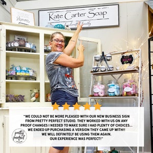 Small business owner displaying custom indoor sign used as personalized office wall art company signage.