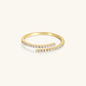 May include: A gold ring with a delicate design featuring two rows of small diamonds set in a continuous line.