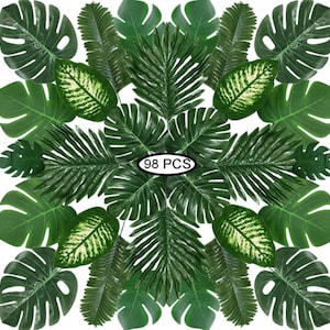May include: A collection of 98 artificial green leaves, including palm leaves, monstera leaves, and other tropical foliage. The leaves are arranged in a circular pattern, with the text "98 PCS" in the center.