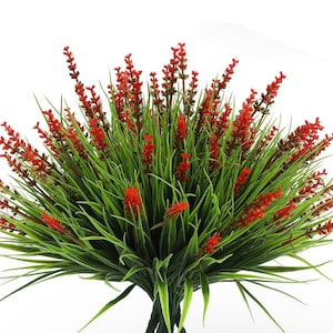 Puede incluir: Un ramo de flores rojas artificiales con tallos y hojas verdes. Las flores están dispuestas en un racimo y tienen un aspecto realista.