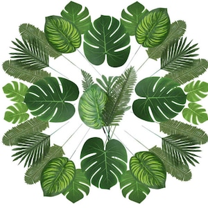 May include: A collection of artificial green tropical leaves, including palm fronds, monstera leaves, and other tropical foliage. The leaves are arranged in a circular pattern, creating a lush and tropical aesthetic.