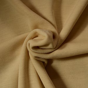 Peut inclure: Un gros plan sur un tissu beige doux avec une texture lisse. Le tissu est plié et drapé, mettant en valeur son drapé et sa texture.