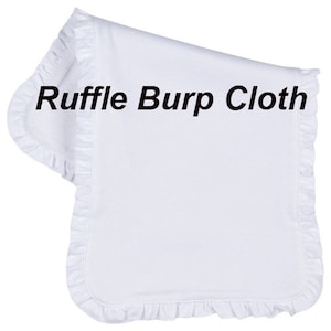 Op de afbeelding: Een witte katoenen spuugdoek met een gerimpelde rand. De tekst "Ruffle Burp Cloth" is in zwart op de doek gedrukt.