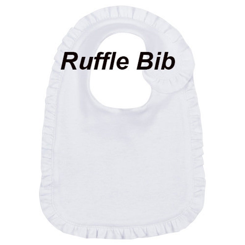 Op de afbeelding: Witte katoenen baby-slabbetje met een gerimpelde rand en de tekst "Ruffle Bib" gedrukt op de voorkant.