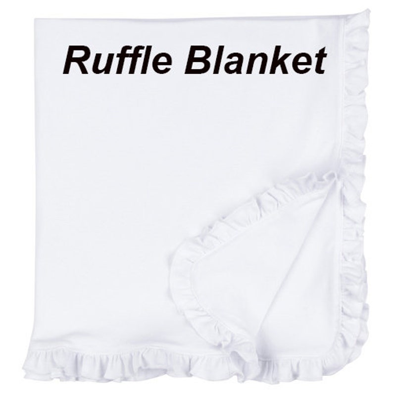 Op de afbeelding: Een wit ruches dekentje met de tekst "Ruffle Blanket" erop gedrukt.